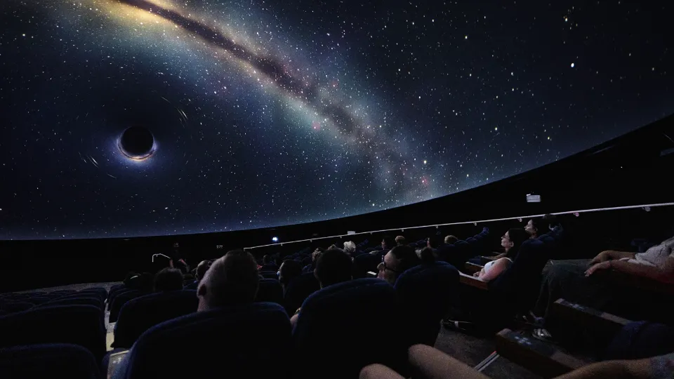 Le public sous le dôme étoilé du planétarium de la Cité de l’espace