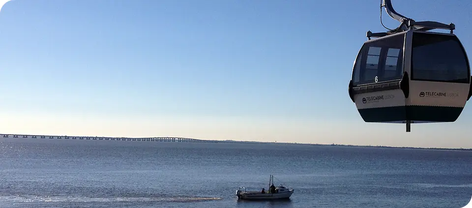 Une cabine de la Telecabine Lisboa au-dessus du Tage, un bateau sur l'eau en contrebas